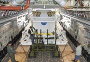 Technicians carefully position an Orion flight test crew module