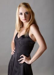 10070046-young-adult-caucasian-woman-with-blonde-hair-and-prominent-jewelry-on-a-neutral-grey-background-with