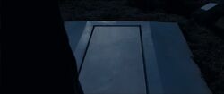Voldemort staring down at the tomb before opening it